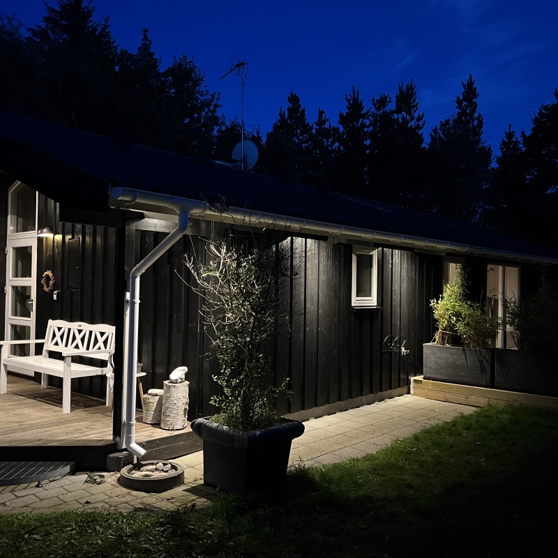 Sommerhus oplyst om natten med terrasse.